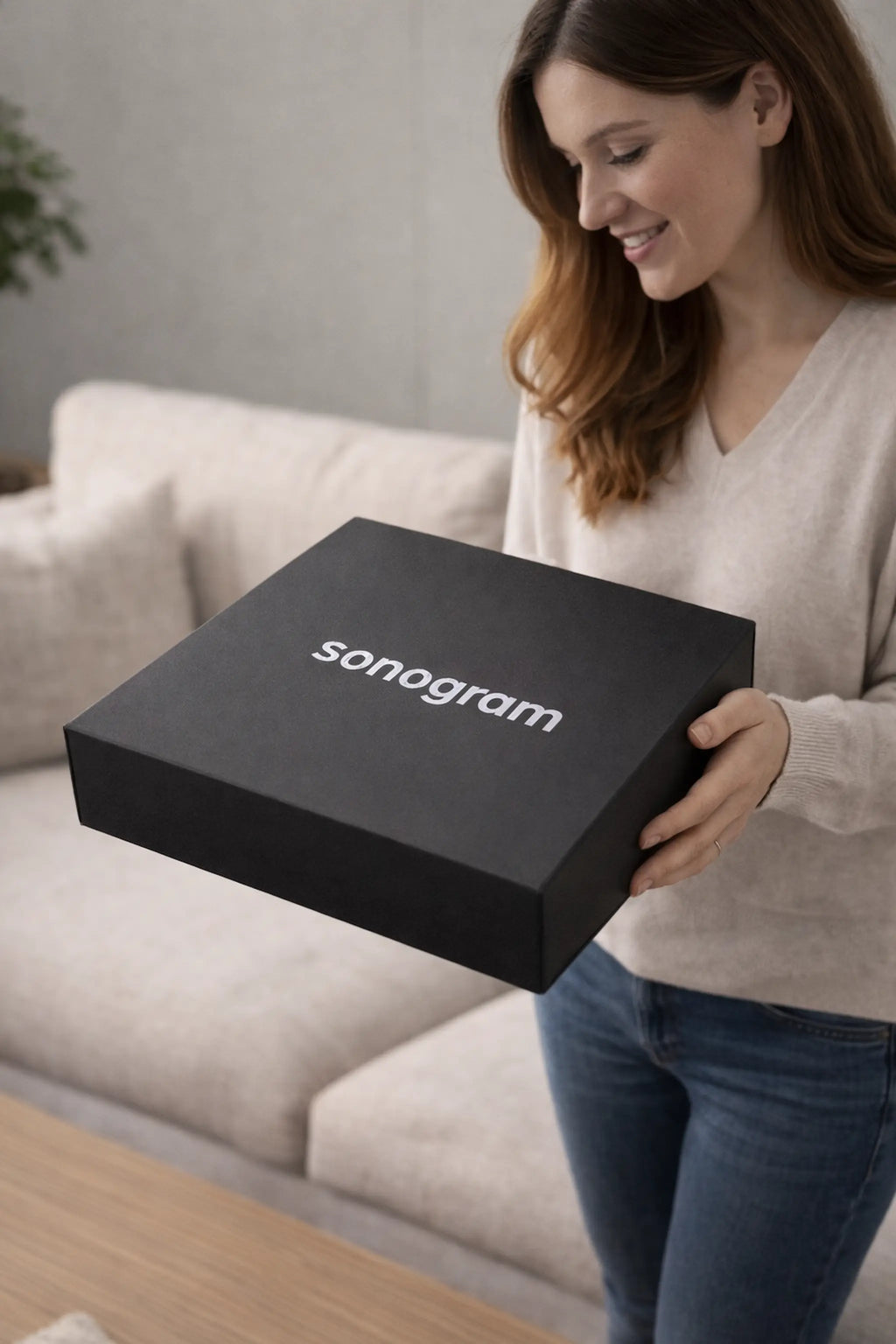 une femme qui tien une boite contenant un sonogram