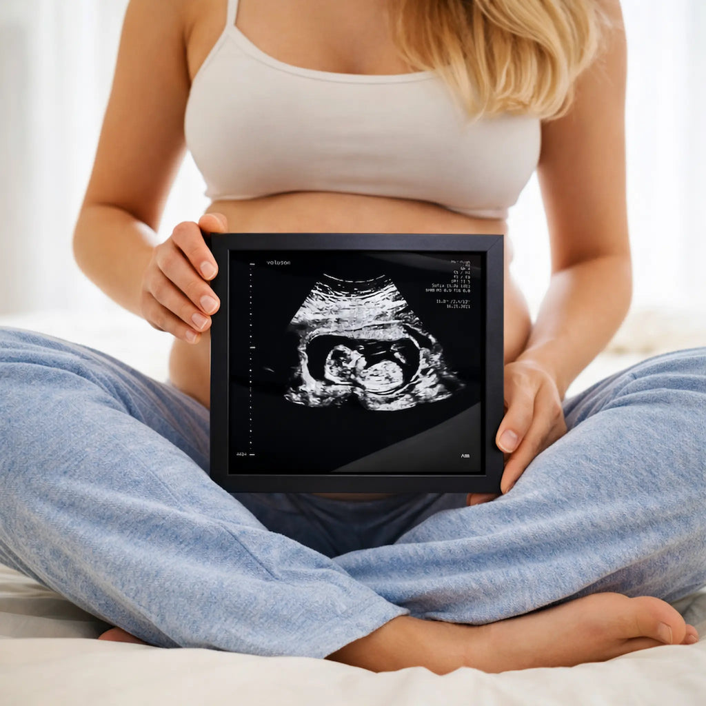 une femme assise en tailleur qui tient un sonogram argent 