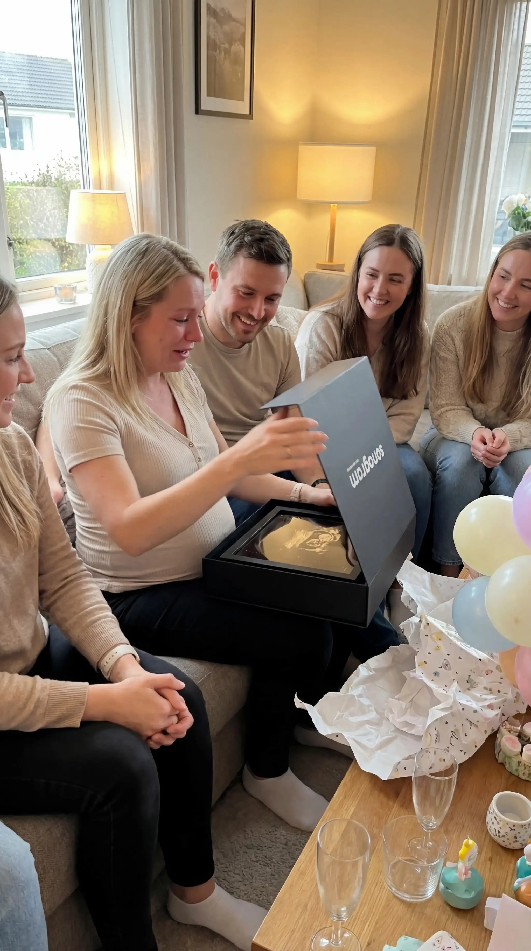 une femme émue qui ouvre un sonogram devant ses amis